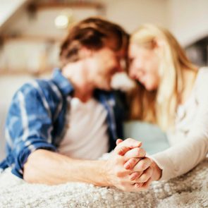 couple holding hands and smiling with foreheads touching