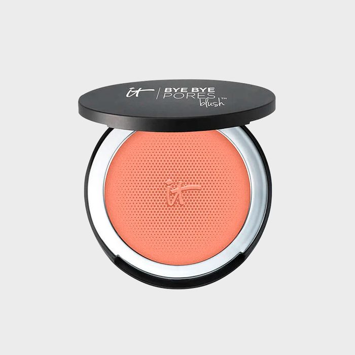 Makeup blush compact, displayed open with coral blush, in a black plastic case. Text on lid: 