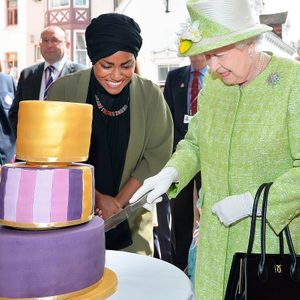 Queen Elizabeth II receives a birthday cake from Nadiya Hussain, winner of the Great British Bake Off, during her 90th Birthday Walkabout on April 21, 2016 in Windsor, England.
