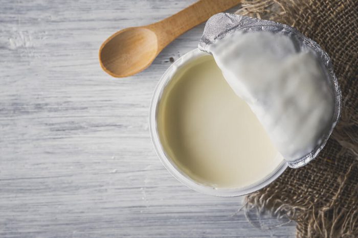 Natural yogurt on the white wooden table top view