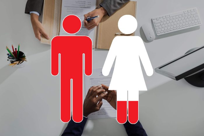 overhead view of hands on opposites sides of a desk with man and woman symbols overlay