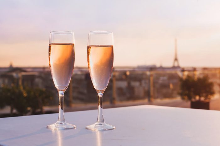 two glasses of champagne at rooftop restaurant with view of Eiffel Tower and Paris skyline, luxury romantic dinner for couple