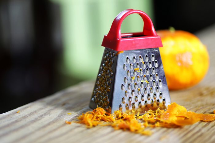 grater zest of citrus fruit and on the wooden table