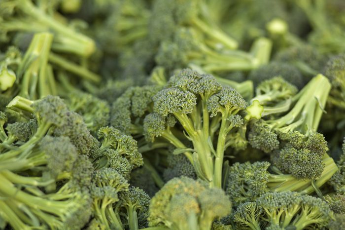 A pile of broccoli stalks at a market.