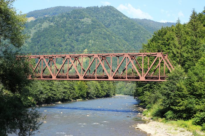 A metal bridge across a mountain river.