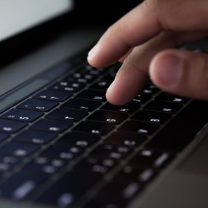 close-up finger typing on keyboard computer working at night