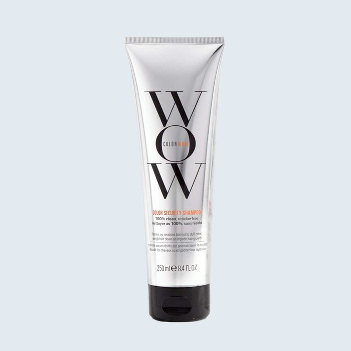A silver shampoo bottle stands upright against a light gray background, labeled 