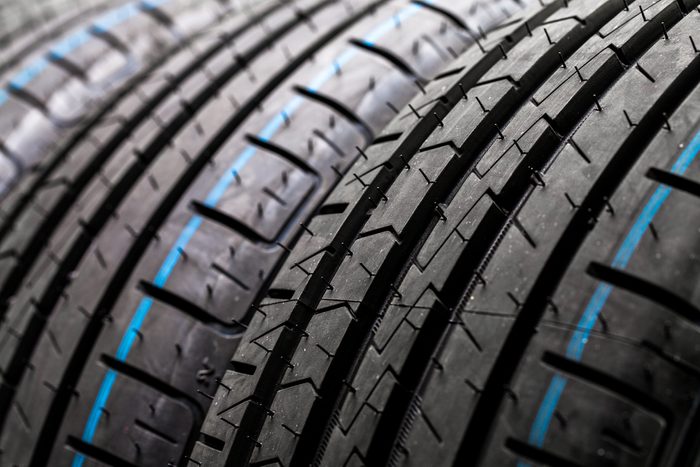 Stack of brand new high performance car tires on clean high-key white studio background