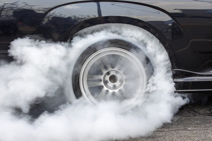 Drag racing car burns rubber off its tires in preparation for the race