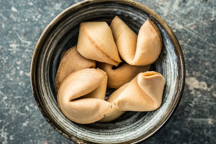 The fortune cookies on chopsticks in bowl. Top view.