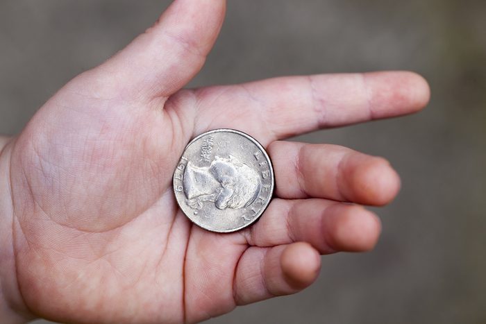 lying in the hand of the child's American coin in a quarter. Photo closeup with a small depth of field.