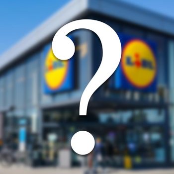 A large question mark obscures the front of a store with logos on a bright, sunny day.