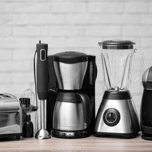 Kitchen appliances on table against brick wall background. Interior element