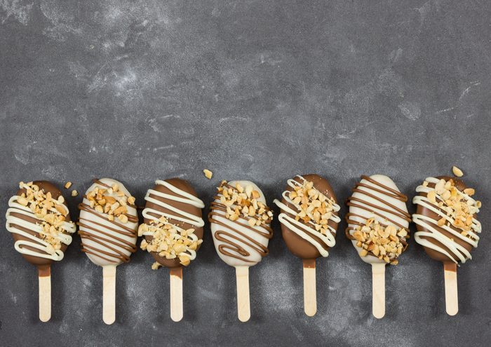 Cake pops in chocolate glaze in form of ice cream on gray stone background