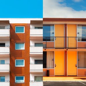 Two adjacent building facades show contrasting architectural styles and colors under a bright blue sky.