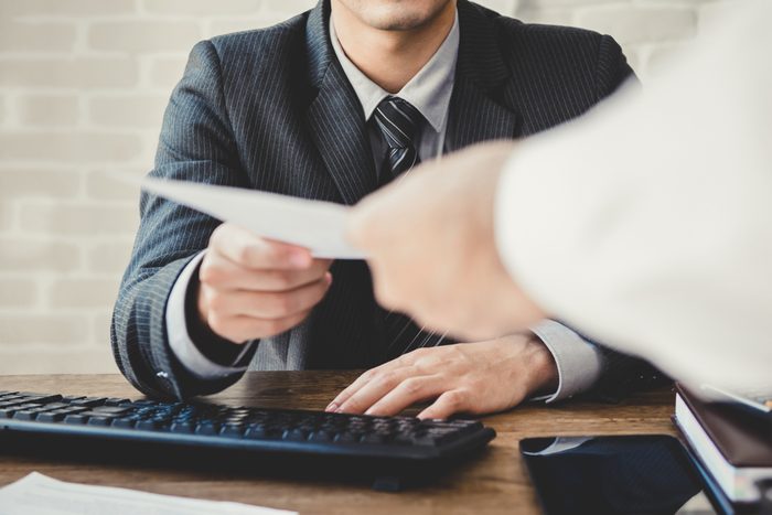 Businessman passing document to manager at the office