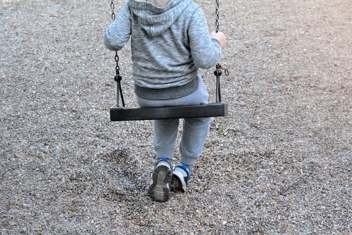 Boy Sitting On A Swing - Lonely Child Concept