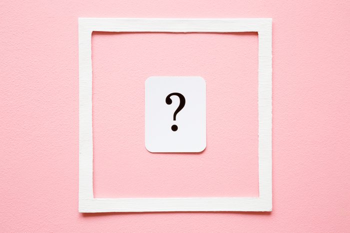 Card of question mark in white frame on pastel pink background. Soft light color. Women issues. Problem and solution concept.