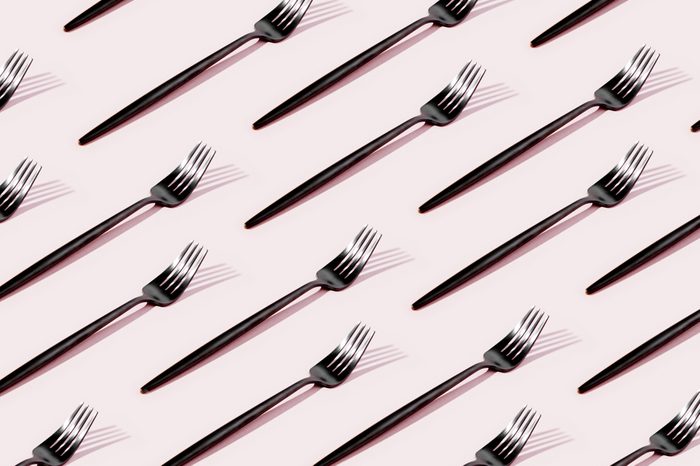 Pattern made of cutlery on pastel background, flat lay, top view. Minimalist concept.