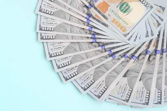 Fan of a US dollar bills of a new design lies on a light blue background
