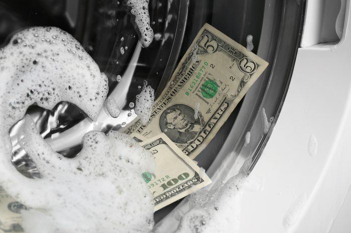 Laundering of dirty money in washing machine, close up