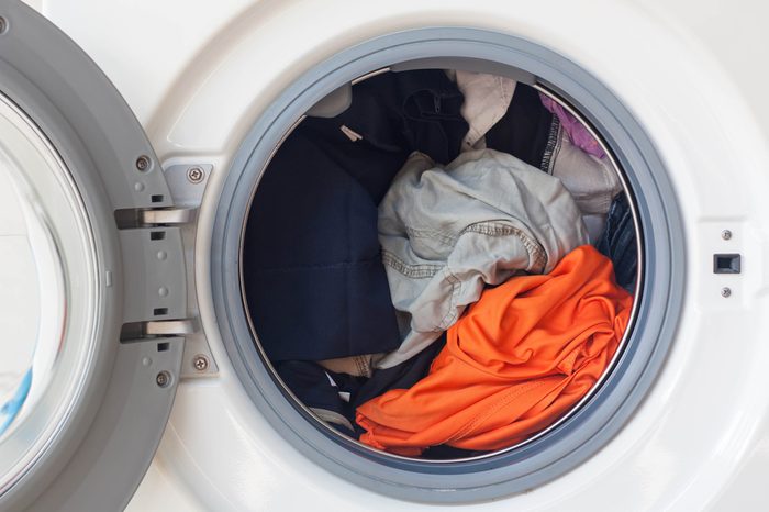 Washing machine full of dirty clothes.
