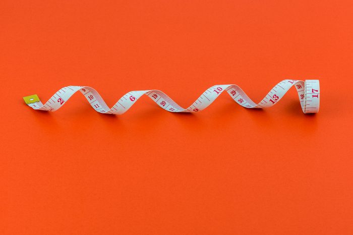 Closeup of Measuring tape on red background