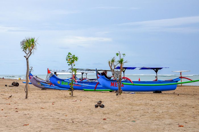 Kuta Beach,Bali,Indonesia-May 28,2010:Boats stand by at the tropical beach in Kuta beach,Bali,Indonesia.Bali island is the most famous island among tourists in Indonesia.