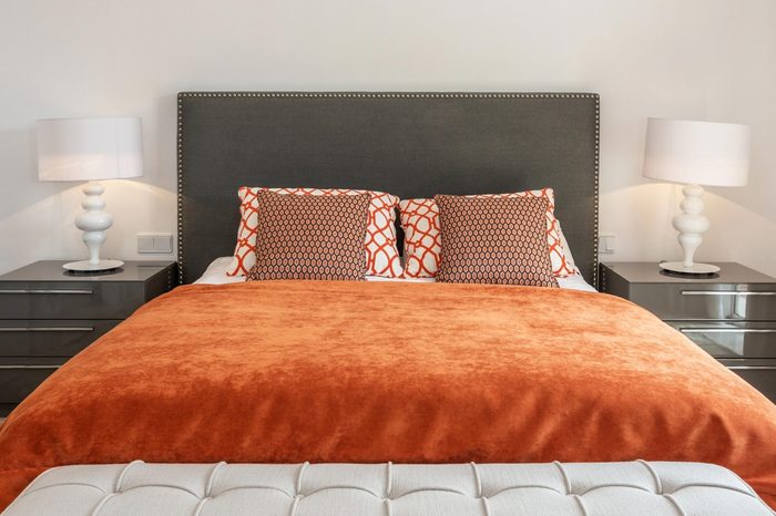 Modern bedroom has a bedroom with a bed and decorative pillows.