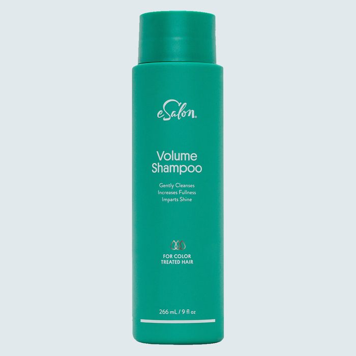 A green shampoo bottle stands upright against a plain background, labeled 