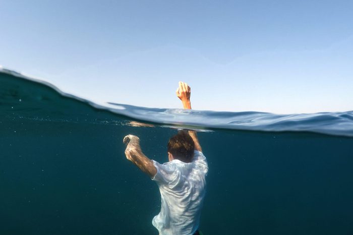 young man sinking into the sea