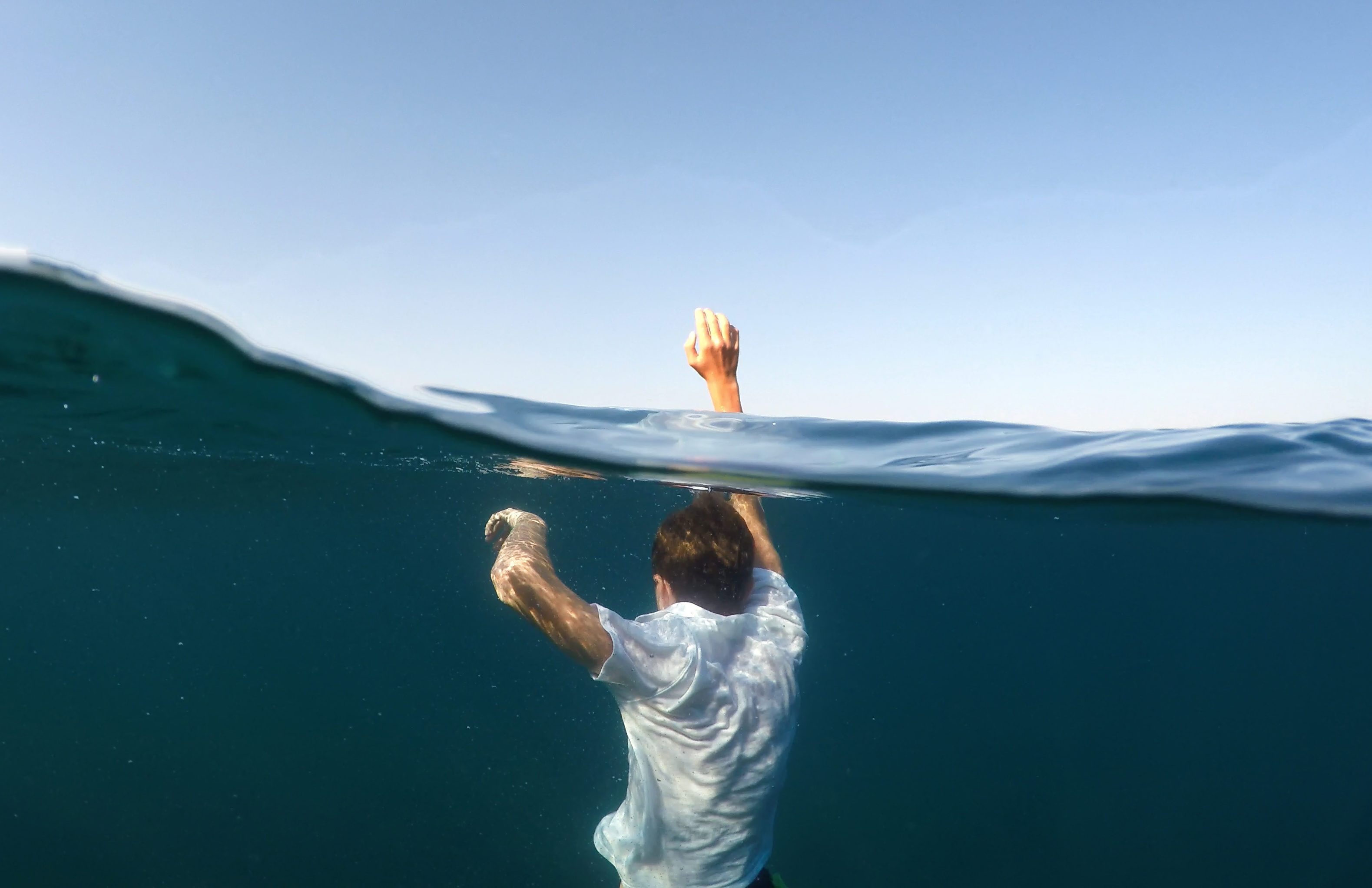 young man sinking into the sea