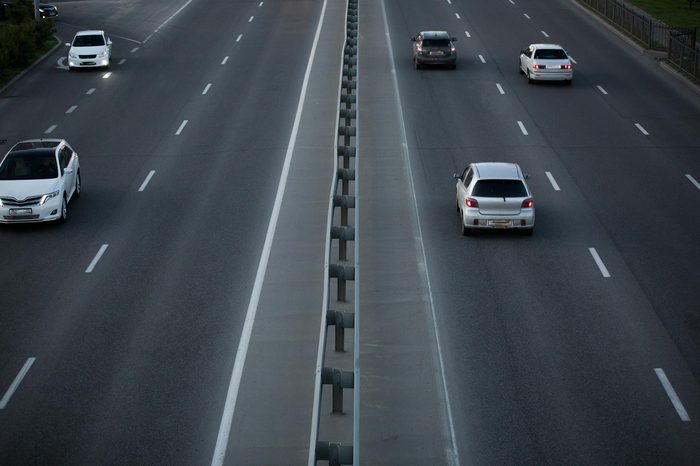 an asphalt road with marking lines and cars. view from above