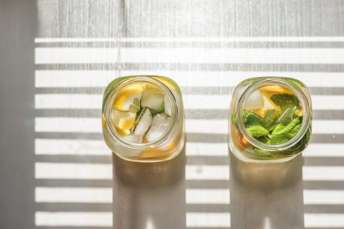 non-alcoholic summer drink with lemon, orange ice, on a light background, high key 