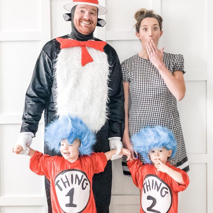 Adults and children wear themed costumes; an adult is a cat, another surprised, while kids dressed as 