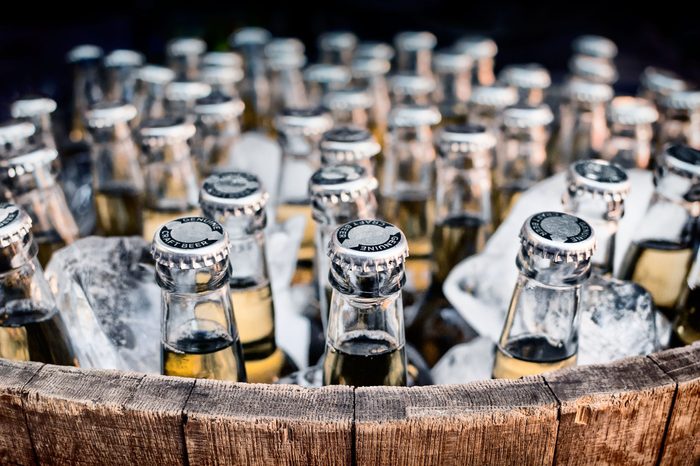 Lots of bottled craft beers in ice in an open barrel
