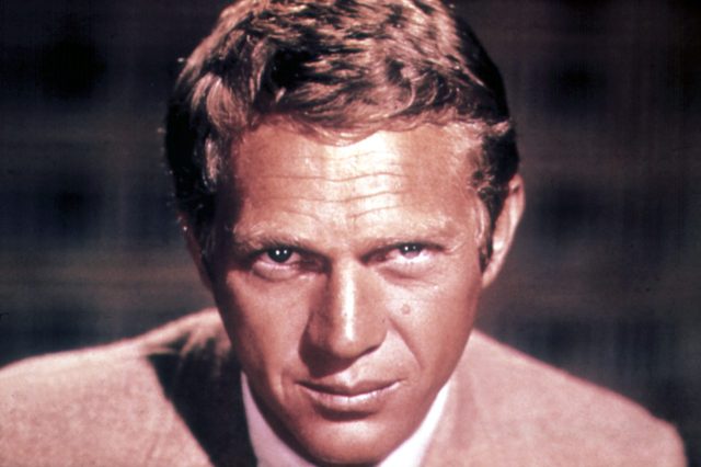Man gazing intently; dressed in a suit; neutral, blurred background.