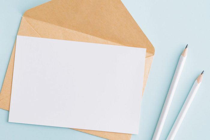 Mockup white wedding invitation and envelope with white daffodils on a blue background