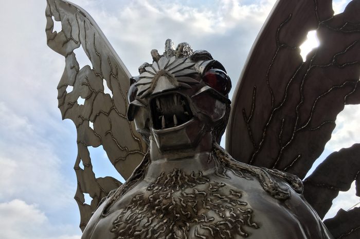 Point Pleasant, West Virginia / USA - September 2, 2019: Silver Mothman Statue Backlit on Cloudy Day