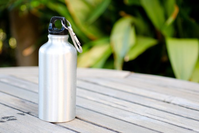 Reusable water bottle on a wooden table outdoors
