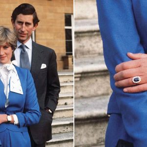 A couple stands together; she wears a blue outfit and displays a sapphire ring. They are in front of a staircase.