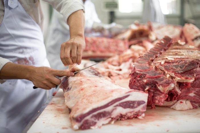Butcher cutting meat food industry concept