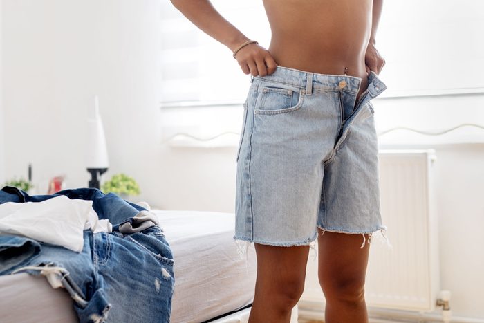 woman trying on shorts that are too big