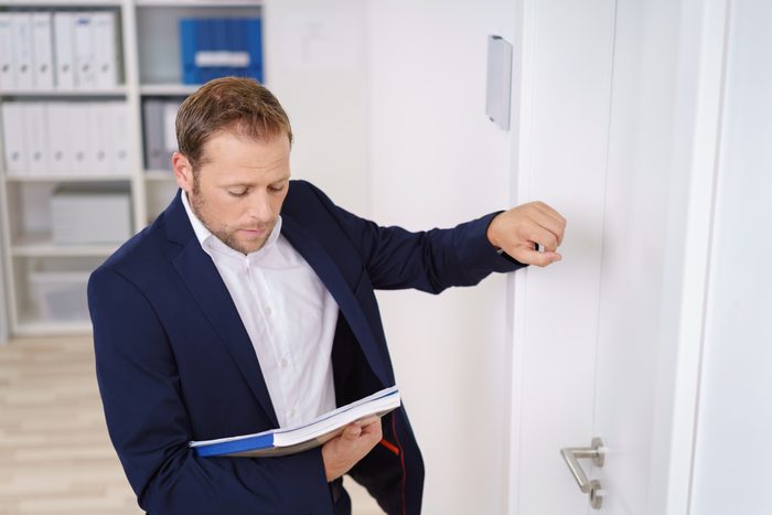 Young businessman knocking on the door of the boss