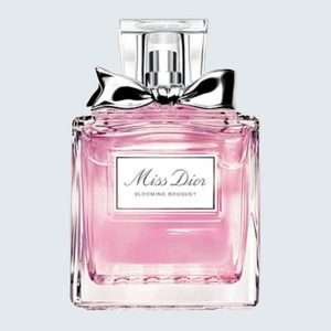 Perfume bottle sits with pink liquid inside, silver bow, and labeled 