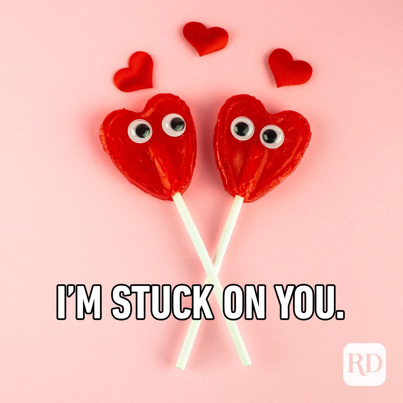 Two heart-shaped lollipops with googly eyes. Meme text: I'm stuck on you.