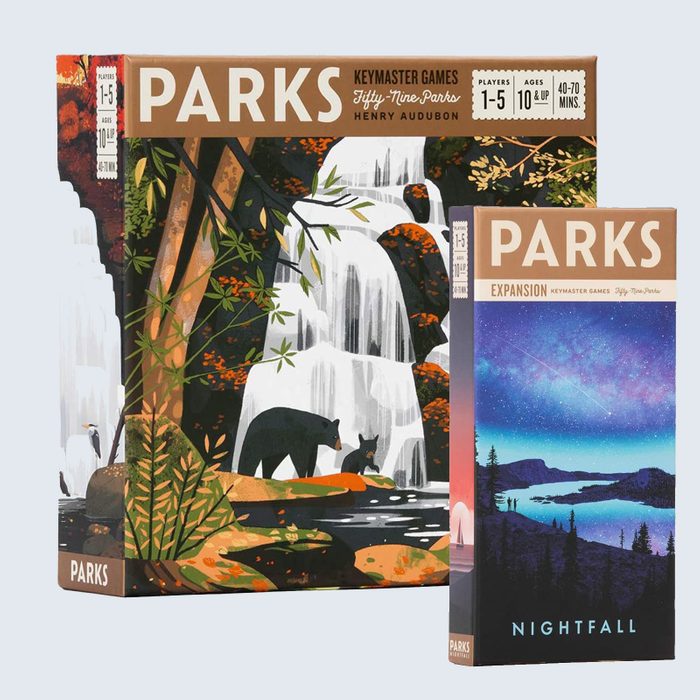 Board game boxes; larger box shows bears near a waterfall in a forest. Smaller box features a night sky with mountains and trees.