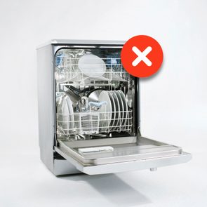 Dishwasher door open displaying dishes inside; a red circle with a white 'X' symbol hovers, indicating an error or warning message.