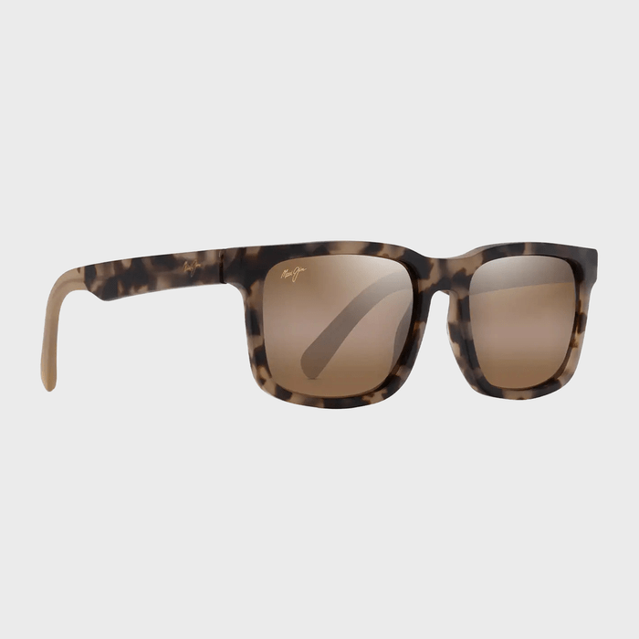 Tortoiseshell sunglasses resting on a light gray background, featuring brown lenses and a signature logo on the temples.