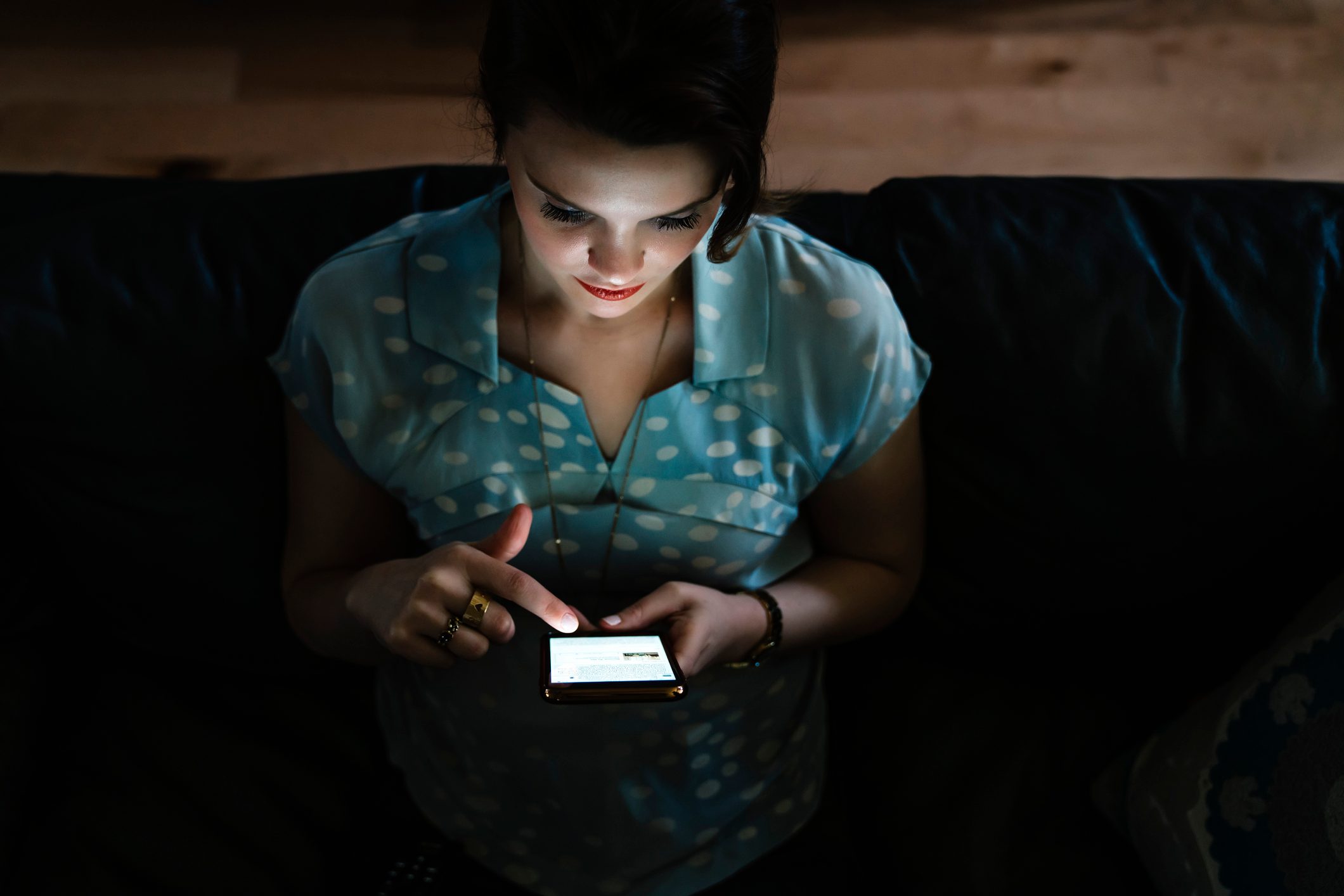 Woman texting on cell phone in the dark